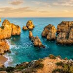 Golden sea cliffs and natural rock arches over turquoise Atlantic ocean at Ponta da Piedade Algarve Portugal
