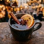 Ultra close-up macro of steaming Gluhwein mulled wine mug with cinnamon and orange at European Christmas market