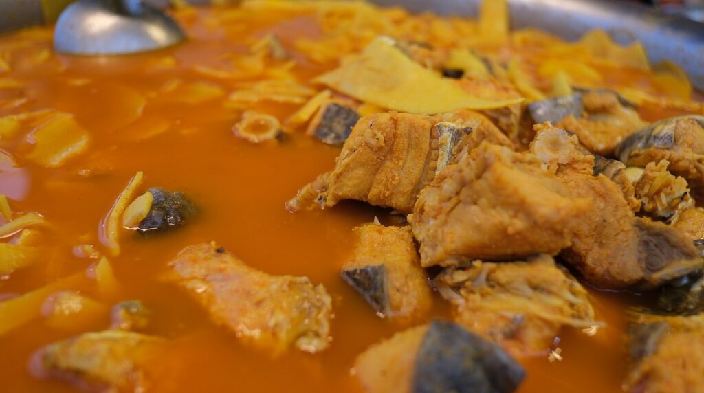 Ultra close-up macro of traditional Icelandic fish stew simmering with cod and winter herbs