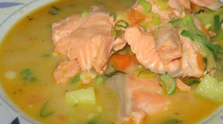 Ultra close-up macro of traditional Finnish salmon soup Lohikeitto with cream and fresh dill in ceramic bowl
