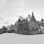 Picturesque winter view of the Rozenhoedkaai canal in Bruges Belgium with historic medieval brick houses and the Belfry tower reflected in calm water