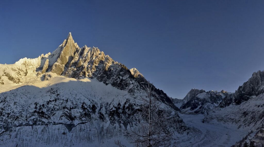 Panoramic view of the snow-covered Mont Blanc massif and sharp granite peaks above Chamonix valley in winter