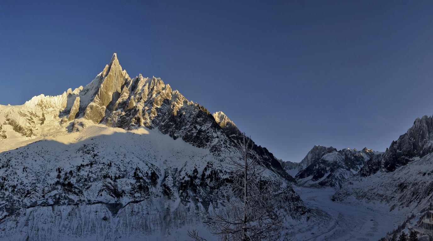 Panoramic view of the snow-covered Mont Blanc massif and sharp granite peaks above Chamonix valley in winter