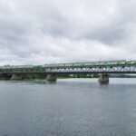 Green and white Finnish double-decker VR night train Santa Claus Express crossing the snowy Ounaskoski bridge into Rovaniemi Lapland in winter
