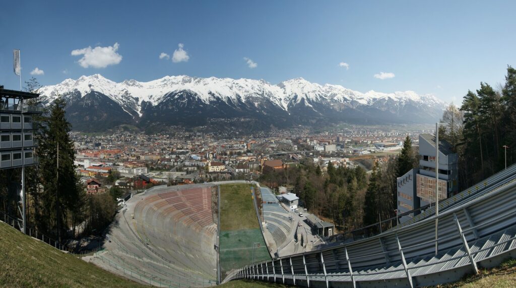 Panoramic view of Innsbruck old town and Inn river framed by snow-covered Nordkette alpine peaks in winter