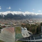 Panoramic view of Innsbruck old town and Inn river framed by snow-covered Nordkette alpine peaks in winter