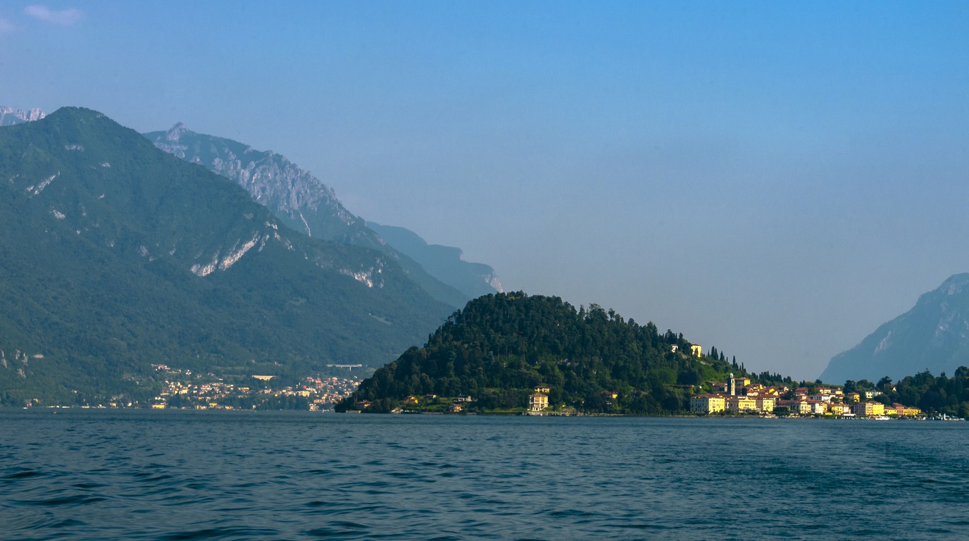 Panoramic view of the Bellagio promontory across the calm blue waters of Lake Como in winter