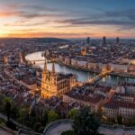 Panoramic golden hour twilight view of Lyon from Fourviere hill overlooking the Saone river, Saint Jean Cathedral spires, and the Presquile peninsula