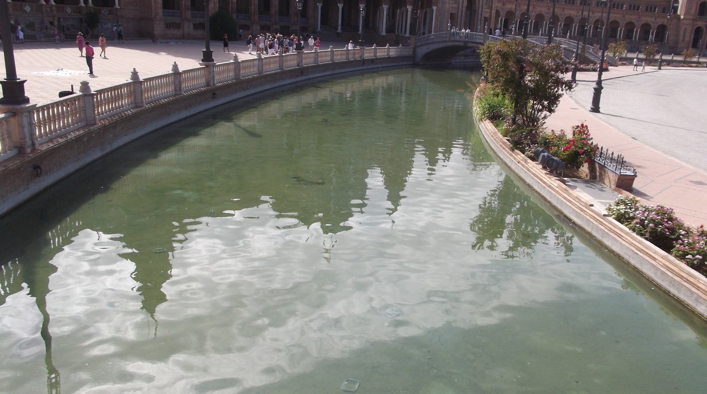 Panoramic view of the ceramic bridges and grand pavilion of Plaza de Espana in Seville under warm winter sunshine