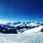 Panoramic alpine view of St. Moritz frozen lake and snow-covered Engadin mountains in winter