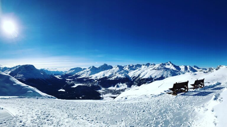 Panoramic alpine view of St. Moritz frozen lake and snow-covered Engadin mountains in winter