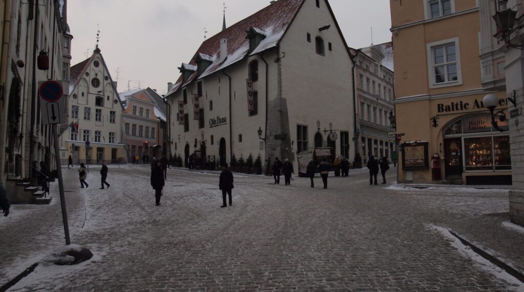 Panoramic winter view of Tallinn Old Town in Estonia with medieval defensive walls red-tiled towers and Gothic church spires covered in fresh snow