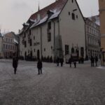 Panoramic winter view of Tallinn Old Town in Estonia with medieval defensive walls red-tiled towers and Gothic church spires covered in fresh snow