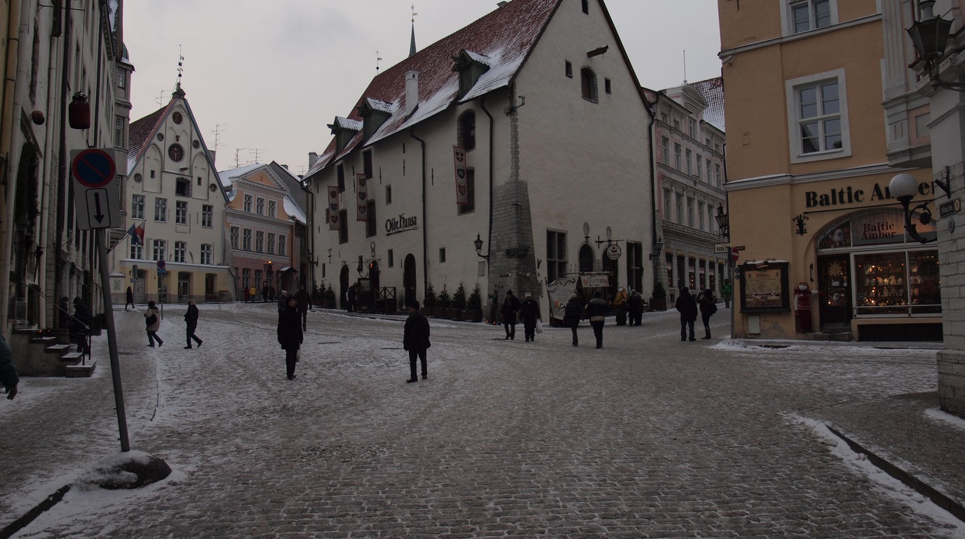 Panoramic winter view of Tallinn Old Town in Estonia with medieval defensive walls red-tiled towers and Gothic church spires covered in fresh snow